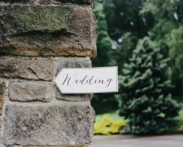 Strzałka z napisem "Wedding" wskazuje drogę do uroczystości, zapowiadając tradycyjny marsz weselny.