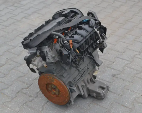 Silnik Alfa Romeo 156, gotowy do montażu. Widoczny koło zamachowe i elementy układu dolotowego.