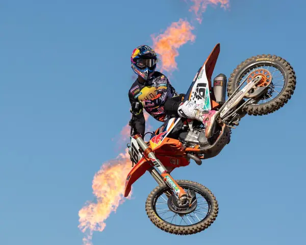 Motociclista Jorge Prado en el aire con llamas saliendo de su moto.
