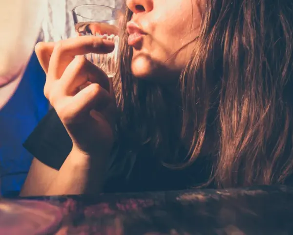 Młoda osoba pije alkohol. Pamiętaj, co grozi za picie alkoholu w wieku 17 lat: problemy zdrowotne i prawne.