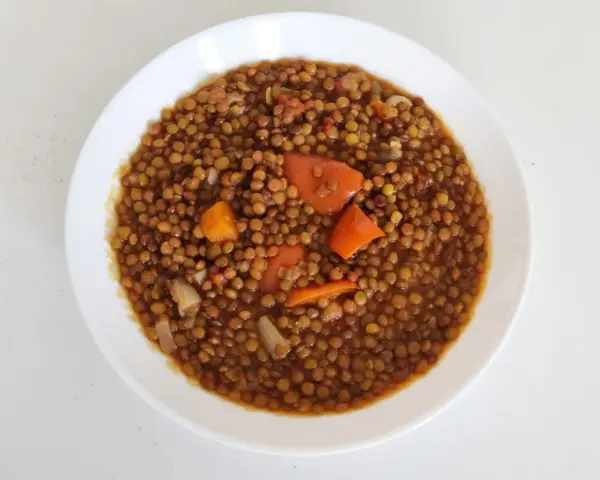 Un plato de lentejas guisadas con zanahoria y cebolla, cocinadas en olla express. Un plato reconfortante y rápido.
