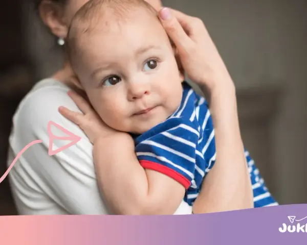 Ciepły uścisk mamy, kiedy dziecko zaczyna się przytulać. Maluch w pasiastym ubranku wtula się w nią z ufnością.