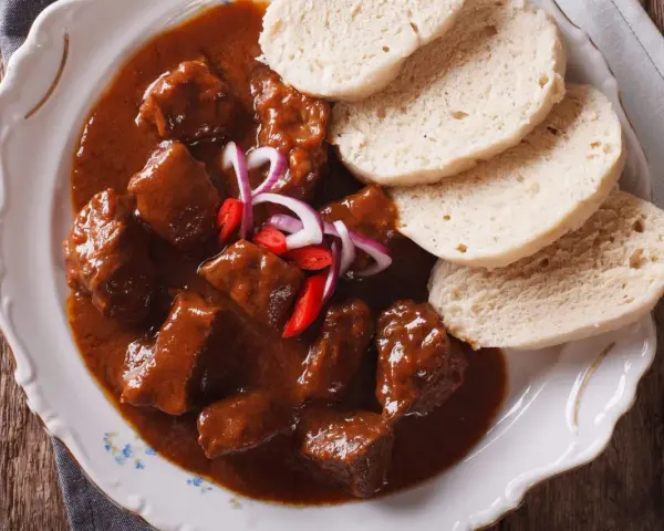 Stracotto toscano succulento in salsa ricca, servito con fette di pane soffice. Un piatto che sa di tradizione.