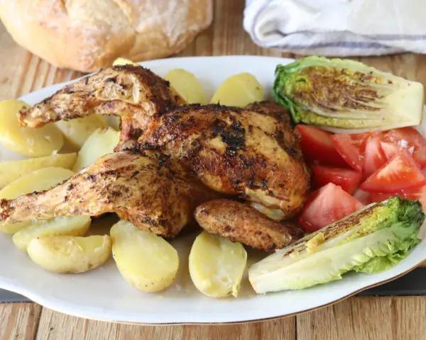 Pollo a la brasa jugoso y dorado, acompañado de papas amarillas, tomates frescos y lechuga a la parrilla. Un festín para los sentidos.