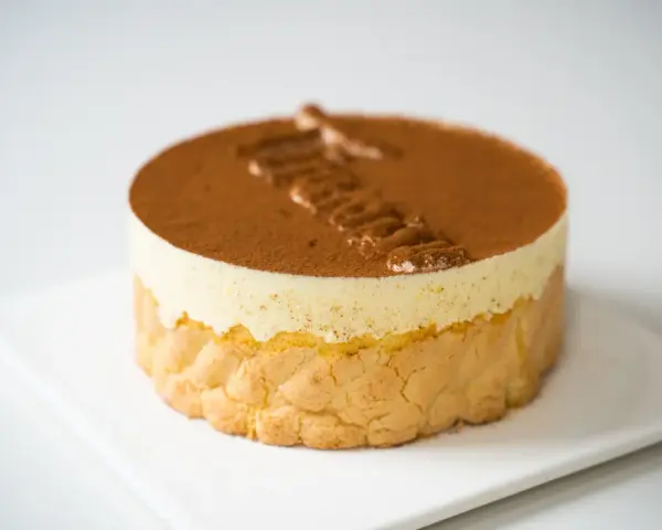 Pyszne tiramisu czekoladowe, udekorowane kakao i kremem. Idealne na deser.