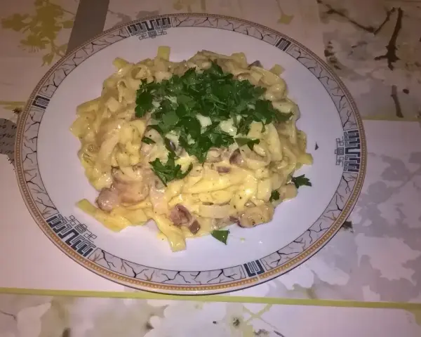 Pyszne fettuccine z boczkiem i pieczarkami, polane kremowym sosem. Idealna odpowiedź na pytanie: jaka śmietana do carbonary?