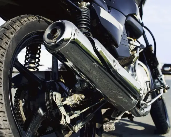 Detalle de la rueda trasera y el escape cromado de una motocicleta. Si te preguntas cuanto cuesta homologar un escape, este podría ser el tuyo.