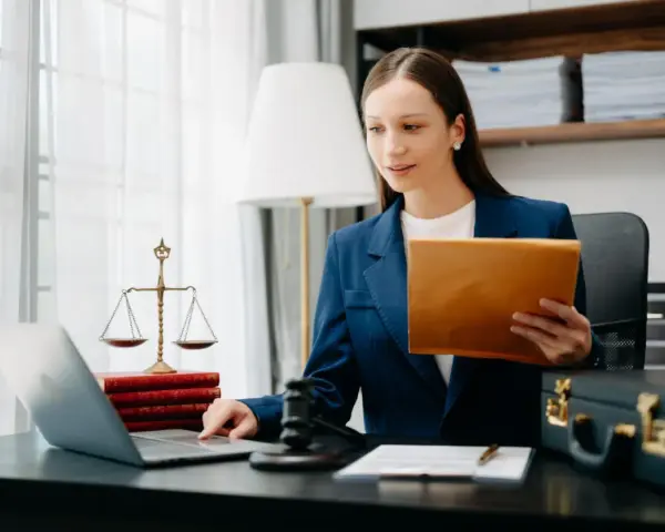 Prawniczka pracuje nad sprawą wdrożenie windykacji, analizując dokumenty na laptopie.