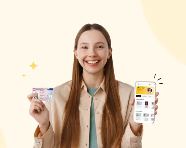Uśmiechnięta dziewczyna trzyma dowód osobisty i smartfon z aplikacją do zdjęć do dowodu.