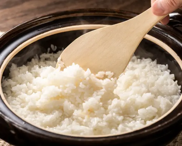 Arroz blanco recién cocido, humeante y esponjoso, listo para servir. Explora los diferentes tipos de arroz y sus texturas.