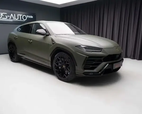 Matowy, zielony Lambo Urus z czarnymi felgami stoi w studiu.