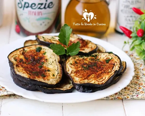 Fette di melanzane in friggitrice ad aria, dorate e profumate, pronte per essere gustate.