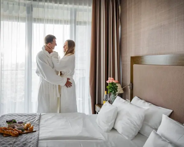 Para spędza romantyczny poranek w szlafrokach, delektując się śniadaniem. Idealny spa nad morzem dla dwojga.