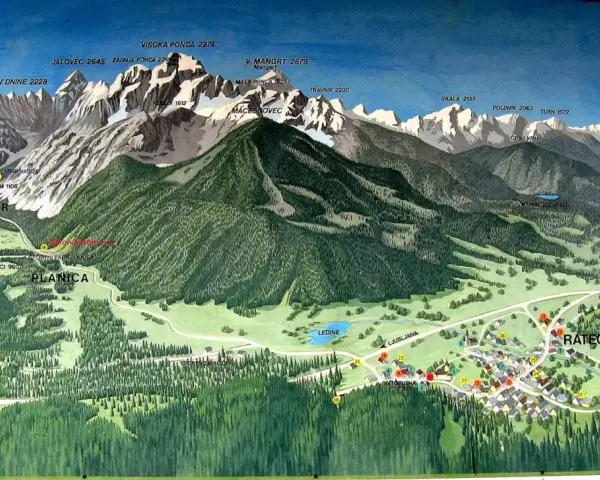Planica, znana zmagovalnih skakalnic, je obdana z veličastnimi gorami, kot so Mangart, Jalovec in Visoka Ponca.