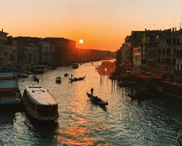 Tramonto sul Canal Grande, con gondole e vaporetti. Un'immagine da uno dei tanti punti panoramici di Venezia, con il sole che illumina l'acqua.