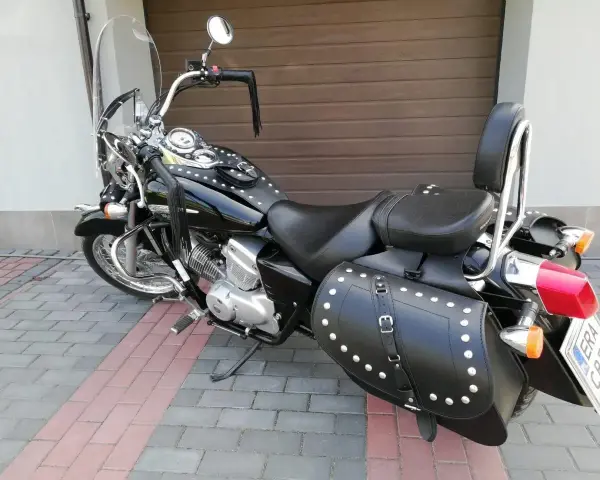 Czarny motocykl Honda Shadow z sakwami i oparciem. Zastanawiasz się, jaki silnik wybrać do tej maszyny?