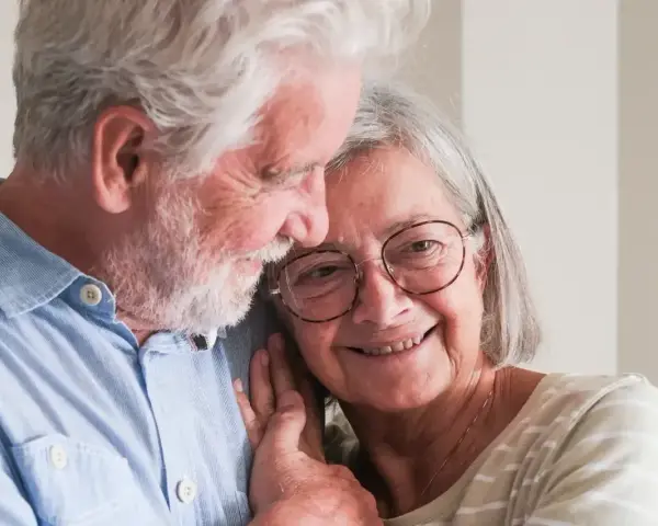 Uśmiechnięta para seniorów, która cieszy się życiem i przywilejami po 75 roku życia. Ich miłość kwitnie.