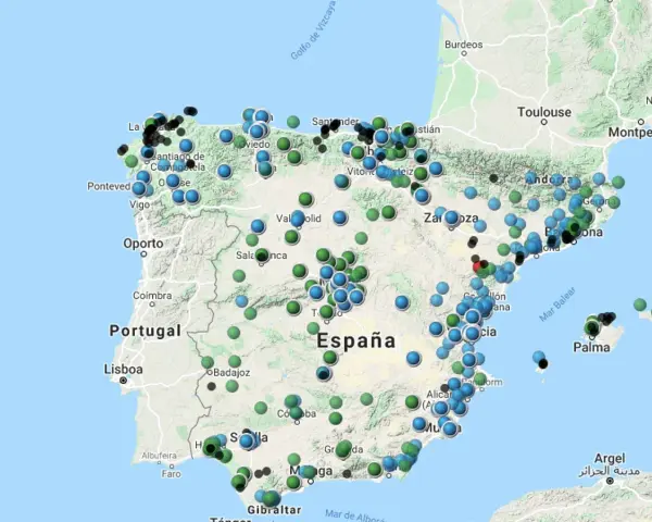 Mapa de España con puntos de colores que indican niveles de contaminacion atmosferica.