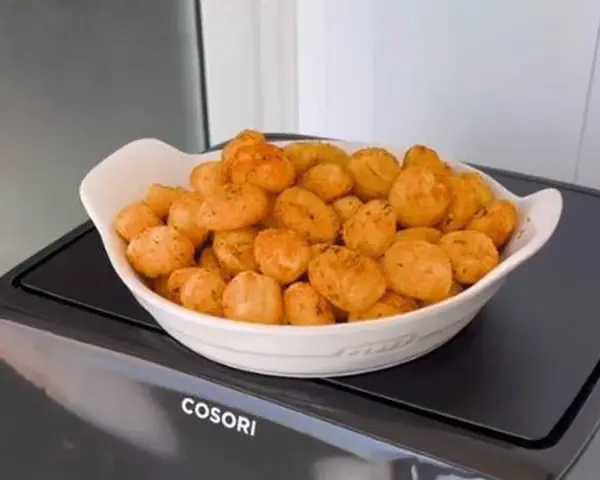 Ñoquis dorados y crujientes en una fuente blanca, recién salidos de la freidora de aire Cosori. ¡Perfectos para picar!