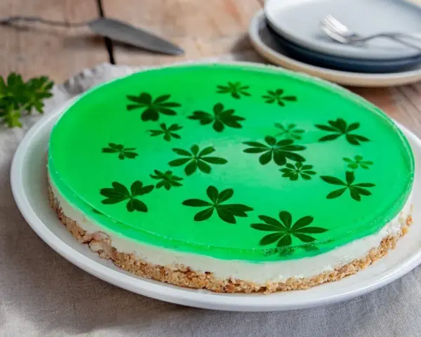 Grüne Philadelphia Torte mit Waldmeister-Gelee und zarten Blüten. Ein erfrischender Genuss!