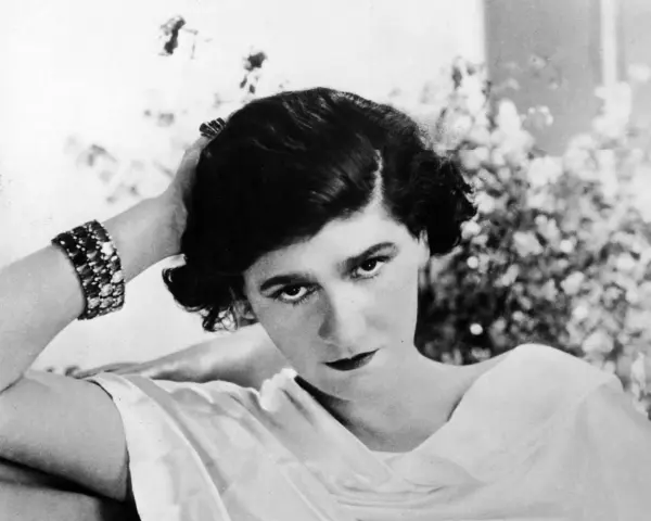 Coco Chanel negli anni '20, con un bracciale scintillante e un'espressione enigmatica.