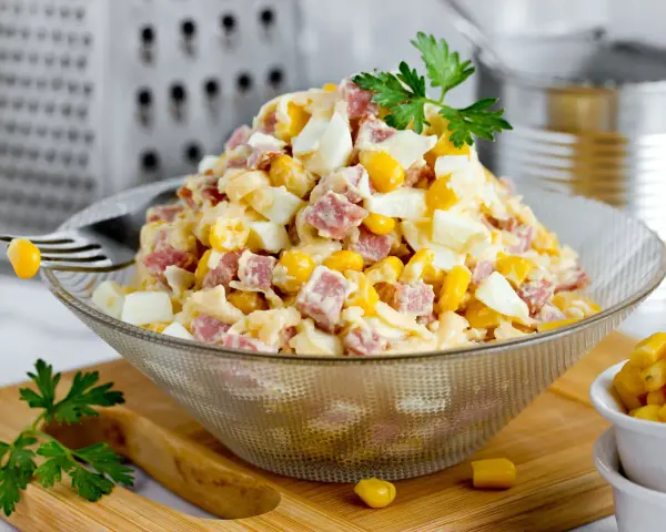 Pyszna keto sałatka z jajkiem, kukurydzą i wędliną, udekorowana natką pietruszki. Idealna na lekki posiłek.