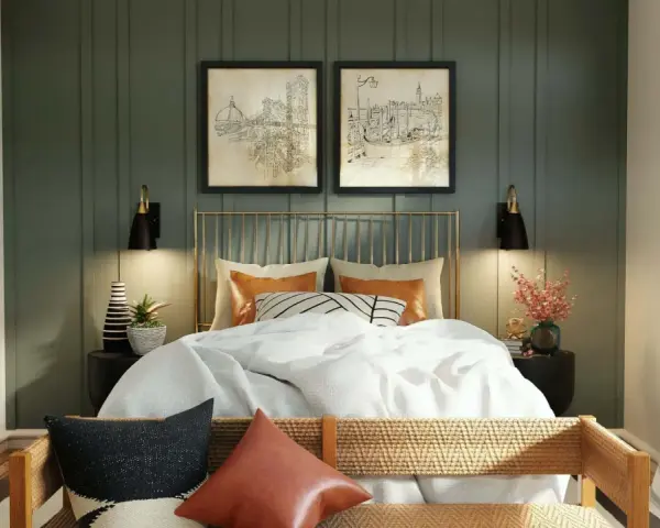 Elegantes dormitorios pequeños con encanto. Cama dorada con ropa blanca, dos cuadros de ciudades y lámparas negras.