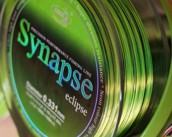 Jaka żyłka karpiowa do dalekich rzutów? Zielona żyłka Synapse Eclipse, 0.331mm, z napisem "Super abrasion resistance", idealna na długie dystanse.
