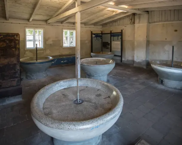 Wnętrze muzeum Stutthof z kamiennymi kadziami, które służyły do prania.