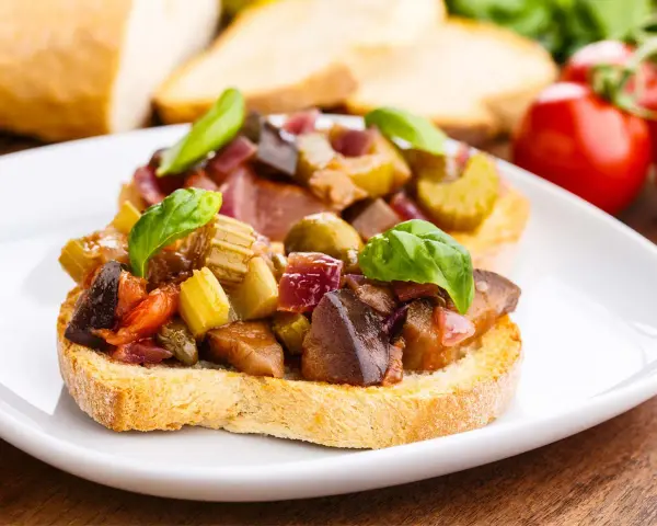 Bruschetta garnie d'un mélange coloré de légumes, évoquant les délices de Capoue.