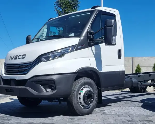 Biały Iveco 70C18, podwozie gotowe do zabudowy, stoi na placu z kostki brukowej.