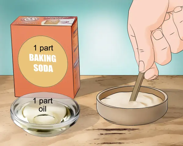 Learn how to remove acrylic glue using a paste of baking soda and oil. A hand mixes the paste in a bowl.