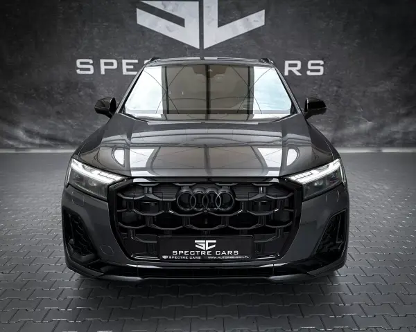 Przód ciemnoszarego Audi Q7 z czarnym grillem i światłami LED.