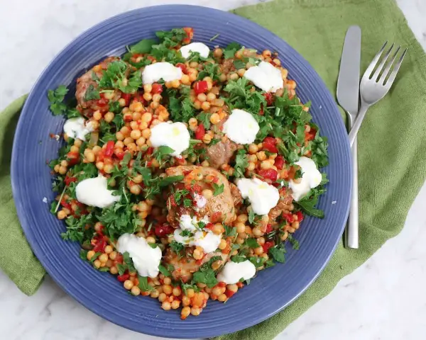 En härlig couscous sallad med kyckling, paprika och färska örter, toppad med krämig ost.