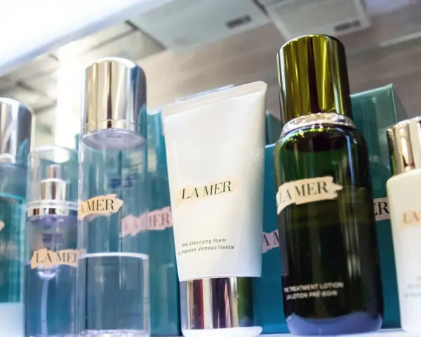 La Mer Kosmetikprodukte in Flaschen und Tuben, darunter eine weiße Tube und eine grüne Flasche.