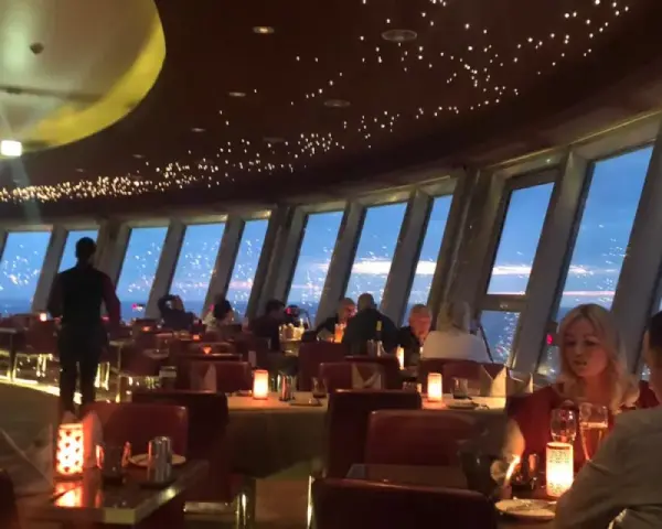 Gemütliches Alexanderplatz Restaurant mit Sternenhimmel-Decke und Panoramablick auf die Stadt bei Nacht.