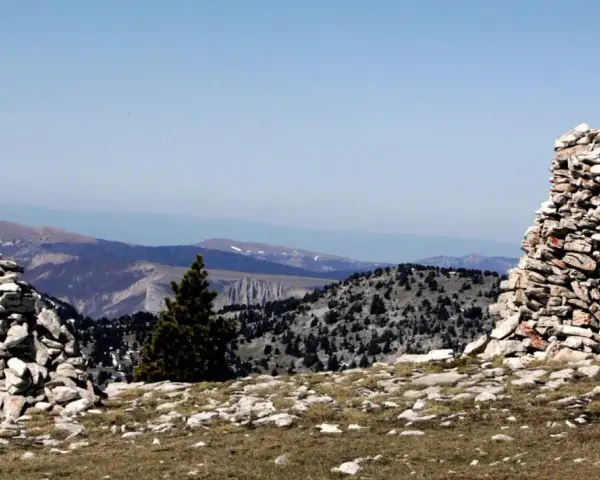 Deux cairns de cailloux marquent le paysage montagneux, offrant des repères visuels sur le sentier.