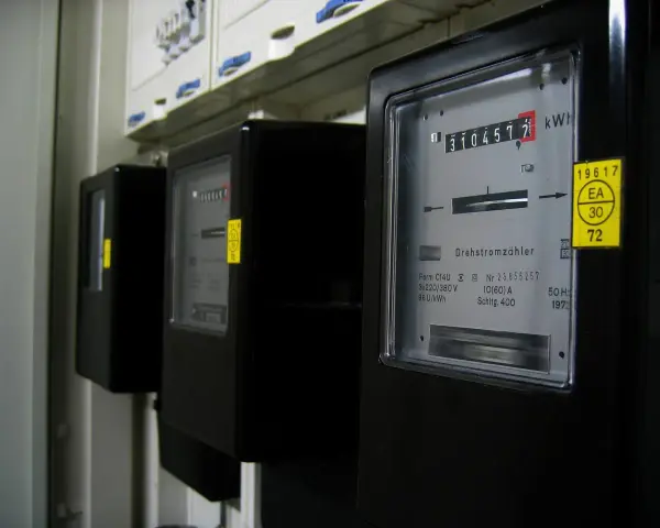 Trzy liczniki energii elektrycznej, jeden z nich pokazuje 3104577 kWh, czyli zużycie energii.
