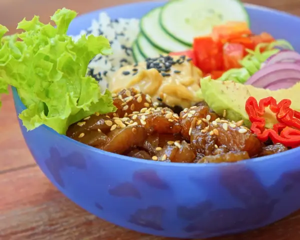 Kolorowy Poke Bowl przepis: ryż, sałata, awokado, ogórek, pomidor, cebula i pikantna papryczka.