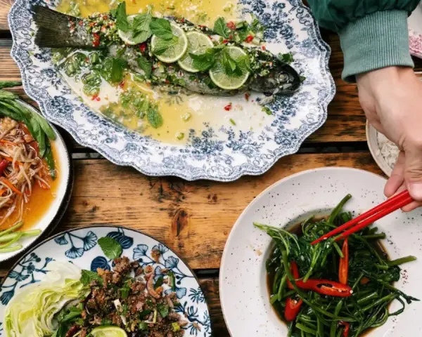 Bangkok Bites Berlin: Ein Festmahl mit gedünstetem Fisch, Papayasalat und Wasserspinat.