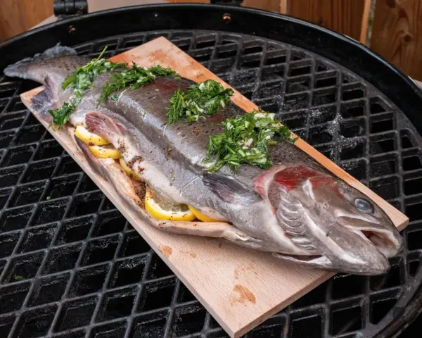 Lachsforelle auf einem Holzbrett, gefüllt mit Zitrone und Kräutern, bereit für den Grill. Die Kerntemperatur ist entscheidend für perfekten Fisch.
