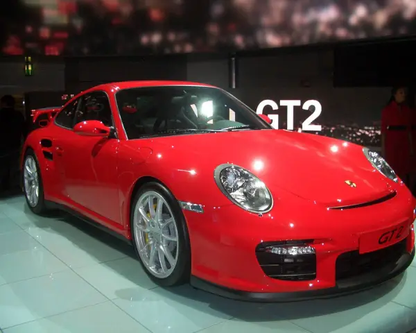 Czerwony Porsche 997 GT2 błyszczy na wystawie, gotowy do jazdy.