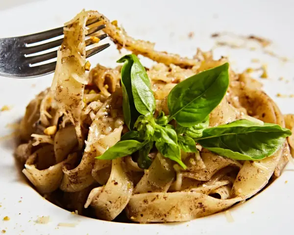 Wide tagliatelle z parmezanem i bazylią, kuszące aromatem, który zdradza, jaki smak ma trufla.