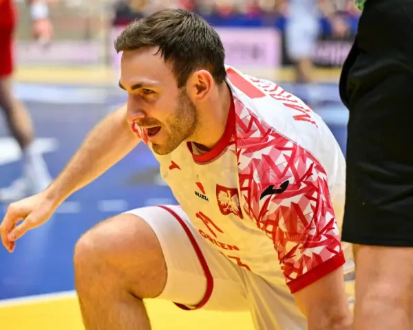 Arkadiusz Moryto w białej koszulce z czerwonymi wzorami, w akcji na boisku.