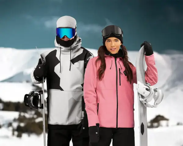 Pareja con tablas de snowboard, ella con chaqueta rosa, él con chaqueta gris y negra. Opiniones sobre Sorona Aura: ¡calidez y estilo en la montaña!
