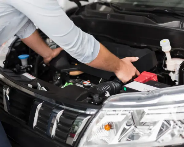 Meccanico controlla il motore per problemi al motorino d'avviamento.