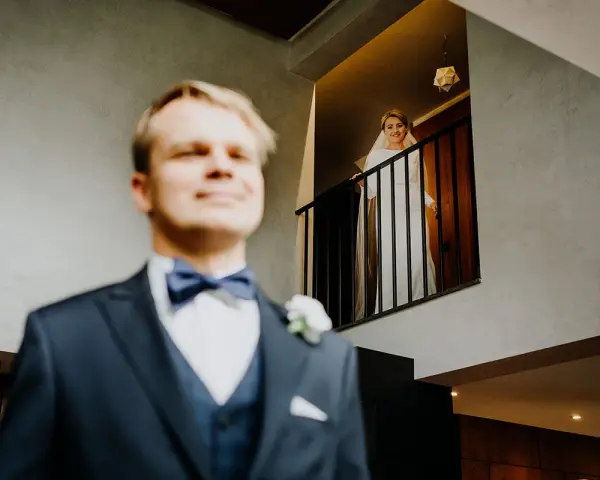 Pan młody w garniturze i panienka młoda w bieli na balkonie. Zastanawiasz się, ile bierze fotograf za wesele?