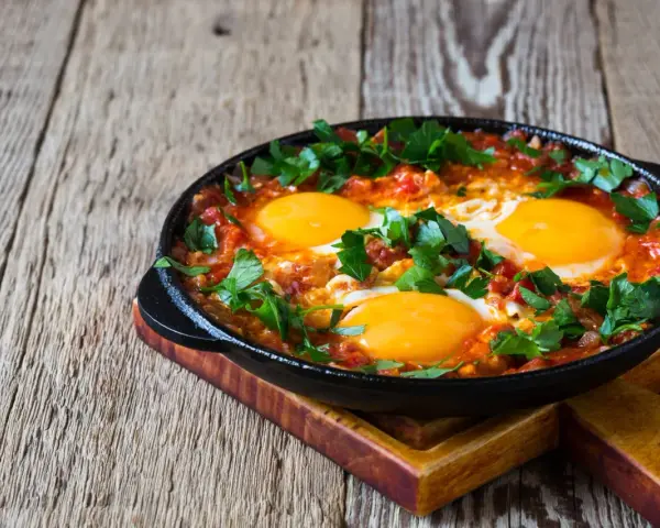 Jajka sadzone w sosie pomidorowym z natką pietruszki, idealne na śniadanie keto. Proste dieta keto przepisy.