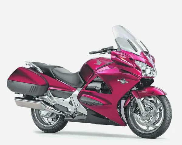 Różowy motocykl Honda ST 1300, gotowy na długie trasy, choć czasem zdarzają się mu drobne awarie.
