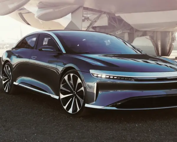 Ciemny sedan Lucid Air na tle samolotu.
